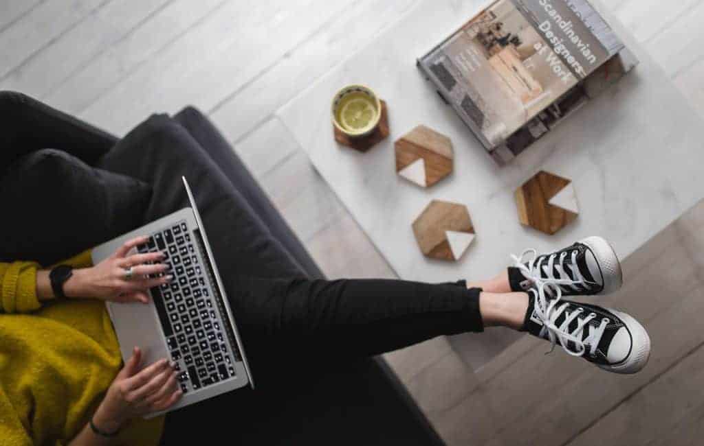 a woman wearing a sneakers working on her laptop