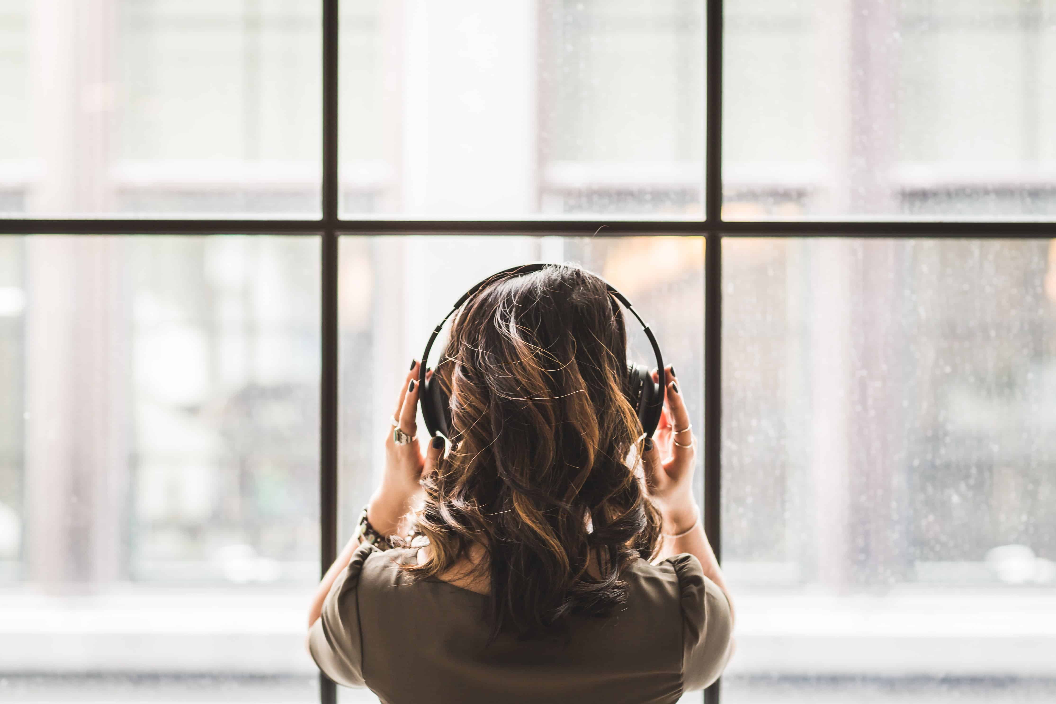 woman facing the window while holding her headset