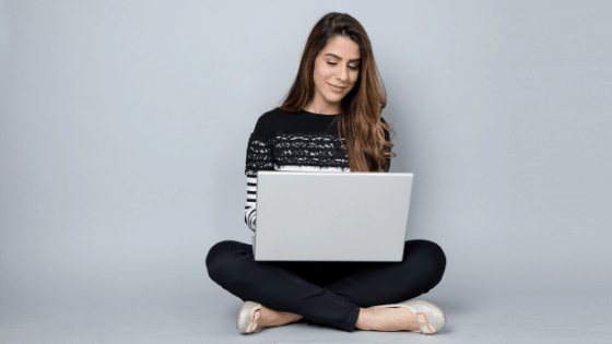 Girl on laptop happily using Pinterest keywords