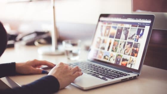 woman browsing pictures in thumbnail size with her laptop