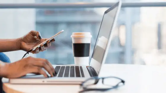 woman texting on one hand and touching the keyboard on the other hand