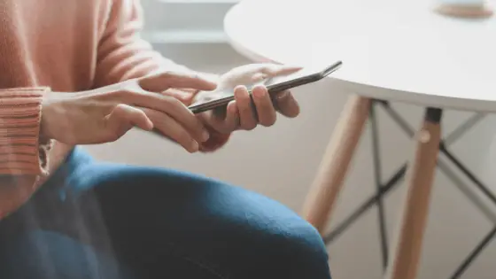 woman's hand touching her phone's screen