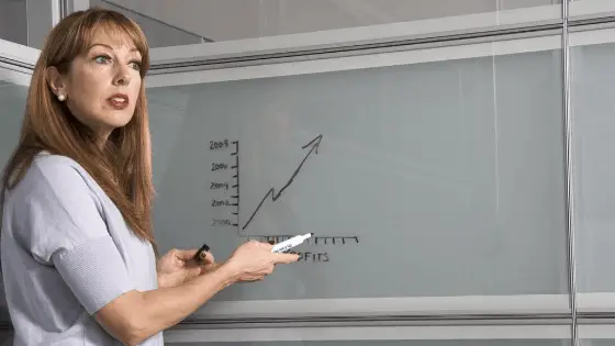 woman explaining the line graph written on the board