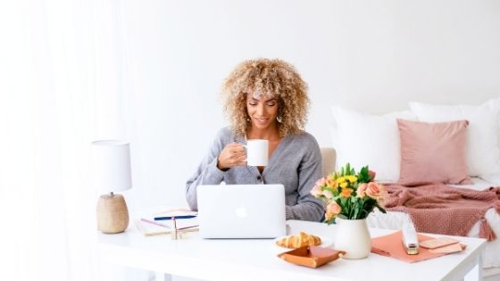 woman sipping coffee while working on her laptop
