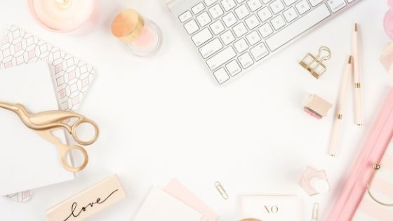 keyboard next to a pen and gold paper clip