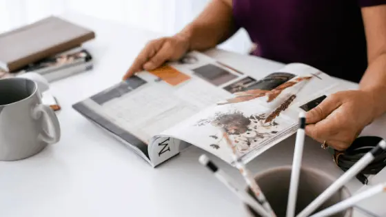 woman's hand flipping pages of a magazine