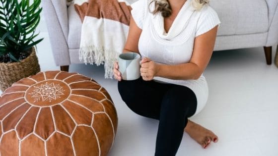 woman sitting on the floor holding a cup 