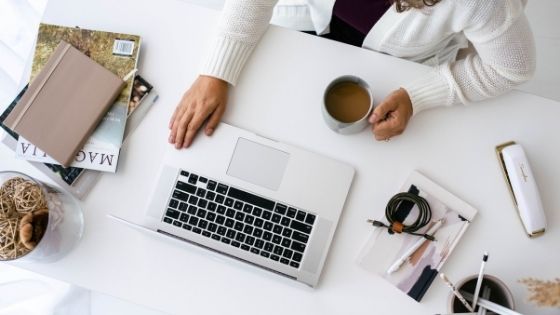 woman's desk with her laptop and coffee