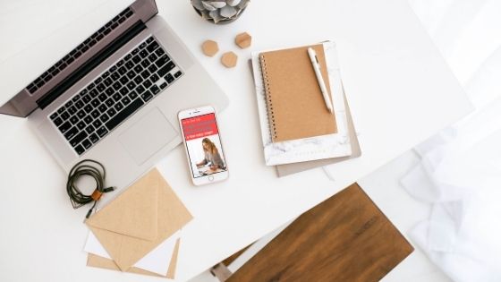 notebooks, phone next to a laptop