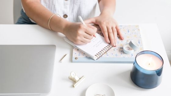 woman jotting some notes on a small notebook