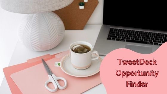 photo of a laptop with a folder and scissors next to a lamp and cup of tea