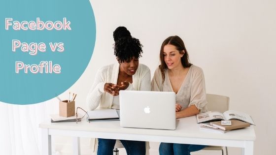 photo of two women sitting a desk looking into a laptop