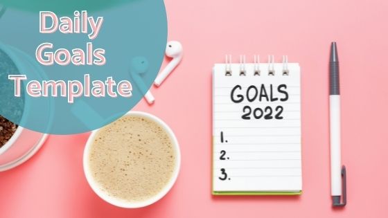 a small notebook with "Goals 2022" written on it next to a coffee and pen