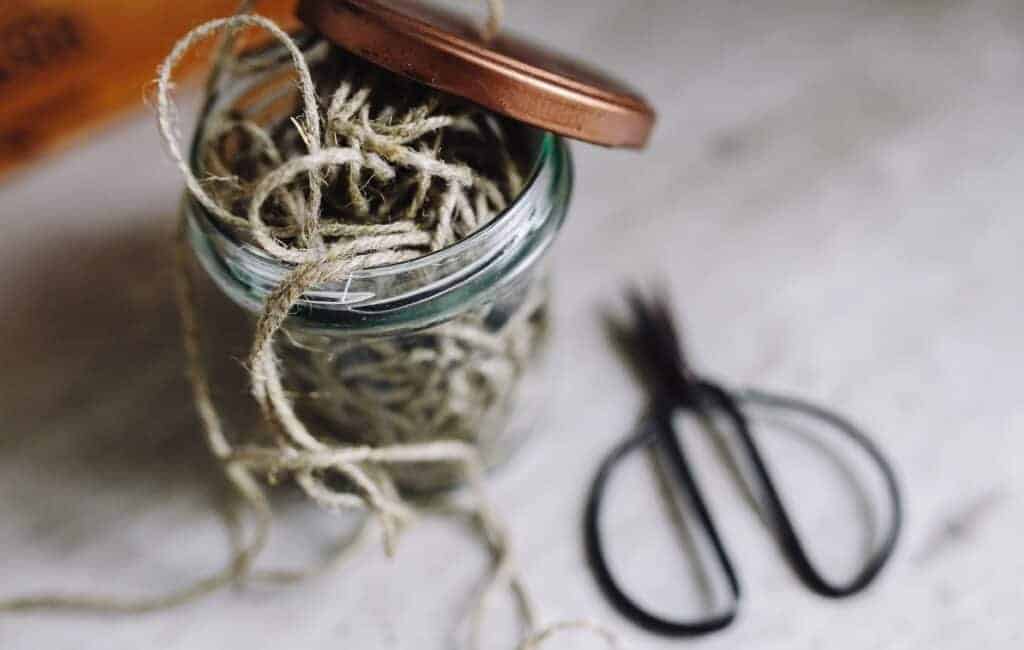 string in a jar next to a scissor