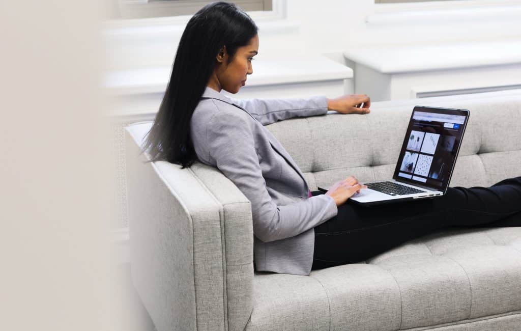woman sitting on a sofa working on her laptop