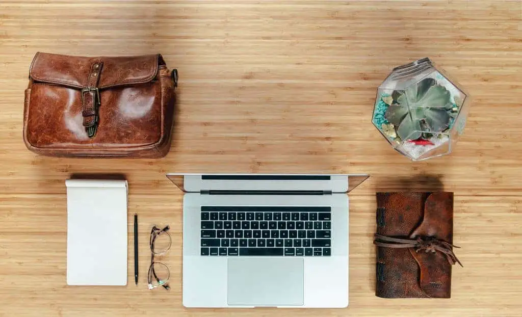 notebook, laptop, a leather bag on a workspace