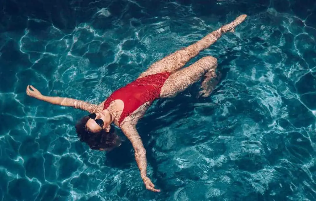 woman with red swimsuit floating in a swimming pool