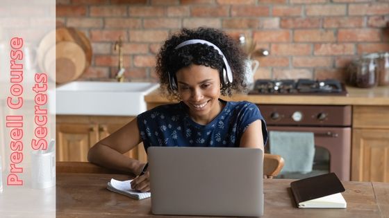 photo of a woman looking at her laptop with headphones on