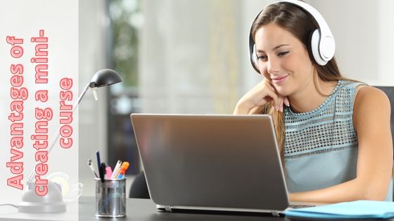 photo of a woman smiling with headphones on looking into her laptop as she considers creating a mini course