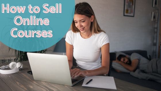 Photo of a woman in a white top sitting at a desk typing on the laptop keyboard doing research on how to sell online courses